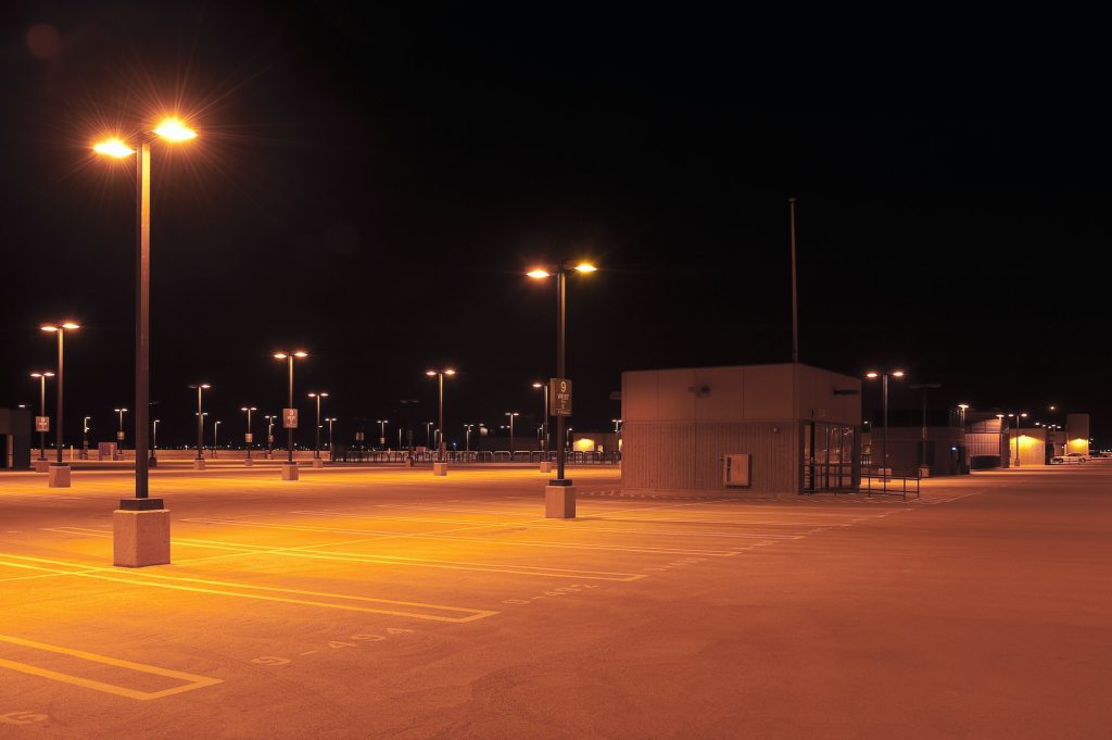 Empty parking lot with street lights at night.